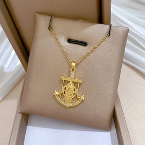 Close-up of gold-plated titanium anchor necklace with Mary relief and rhinestones