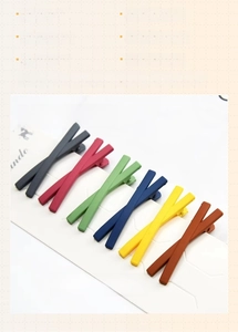 Macro shot of 14 matte cross hair clips in candy colors on display card for hair styling