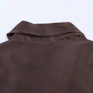 Detail view of smooth dark brown satin fabric and collar stitching of the dress