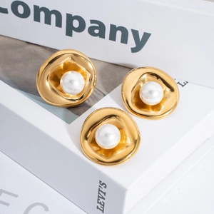 Irregular gold wave earrings set with center white pearls on a minimalist background