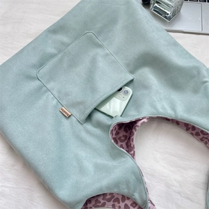 Detail of mint green suede tote with pink leopard lining and outer phone pocket
