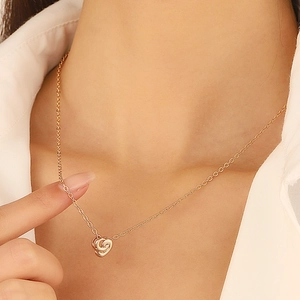Collier élégant avec pendentif cœur tourbillonnant en or rose sur une femme