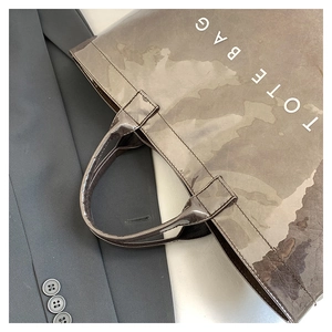 Macro detail of the vintage textured waterproof tote bag with sturdy handles and lettering