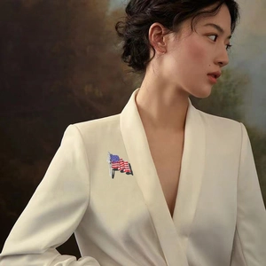 Détail d'une broche drapeau américain avec strass sur un blazer beige
