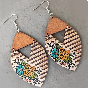 Detail of bohemian geometric wood earrings with sunflower and stripe patterns
