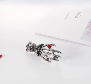 Detailed view of punk skeleton hand brooch featuring red rhinestones and silver alloy