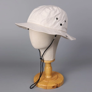 Detail of breathable eyelets and adjustable windproof drawstring on beige sun hat
