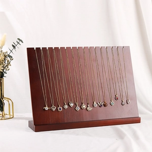 Wooden necklace display stand with multiple gold pendants shown in a professional studio setting