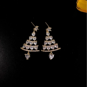 Golden Christmas tree earrings with sparkling heart-shaped crystals on black background