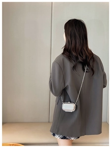 Silver mini acrylic suitcase crossbody bag shown on a model for size and style reference