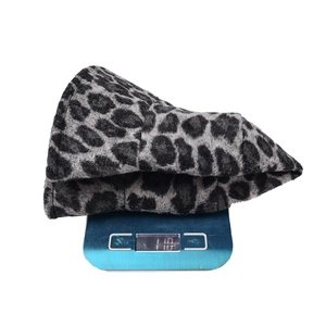 Bob en peluche à motif léopard gris et noir pesé sur une balance électronique bleue
