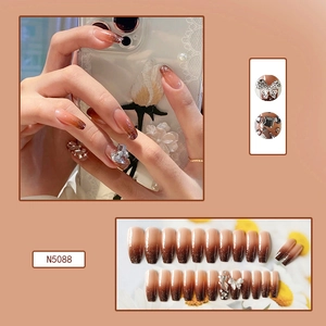 Detailed macro view of coffee gradient press-on nails with 3D bow rhinestones and glitter