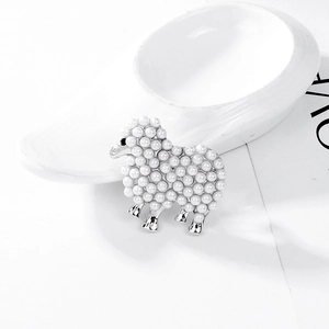 Détail de la broche mouton en perles blanches et base en métal argenté poli