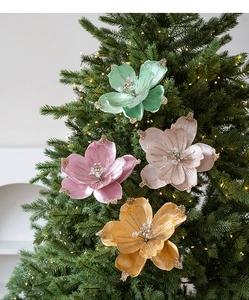 Close-up of velvet Christmas magnolia flowers with glitter edges on a lighted tree