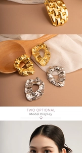 Detailed macro view of vintage hammered gold and silver plated irregular earrings