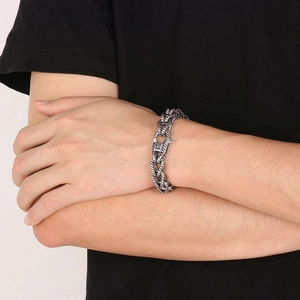 Detailed close-up of retro silver twist-patterned steel chain bracelet on wrist