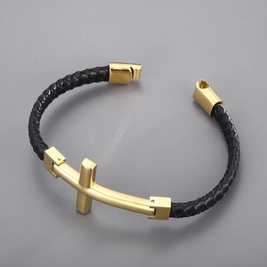 Close-up of a woven black leather bracelet featuring a gold metallic cross and buckle