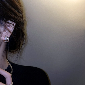 Vue détaillée de boucles d'oreilles géométriques dorées en C avec micro-pavage de diamants