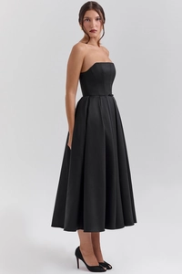Detail of elegant black strapless corset midi dress with structured seams and satin finish