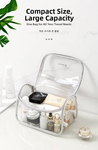 Close-up of large transparent PVC makeup bag with skincare products on marble