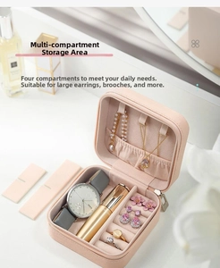 Detailed interior of a pink leather jewelry box with compartments for watches and rings