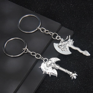 Viking double axe keychain in polished metal with embossed patterns on dark background
