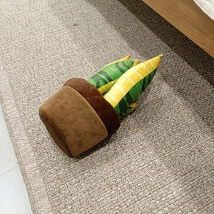 Vue détaillée de dessus d'un jouet en peluche pot de fleurs souple sur un tapis