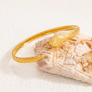 Macro shot of 18k gold plated stainless steel snake bangle with scale texture detailing