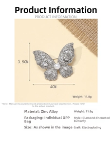 Macro shot of silver butterfly brooch with 12 sparkling crystals and a central pearl detail