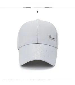 Detail der hellgrauen Mesh-Baseballkappe mit dekorativem Fashion-Logo aus Metall auf Krone