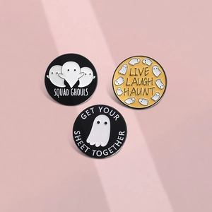 Three minimalist Halloween ghost enamel pins with funny captions on a pink background