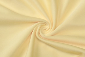 Macro shot of light yellow fabric texture showing fine weave and soft material detail