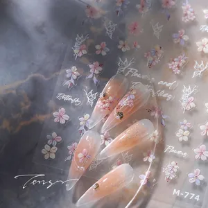 Detail van nagelstickers M-774 met bloemen, vlinders, goudfolie en parels