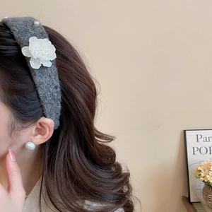Side view of grey knitted headband featuring 3D white flowers and delicate pearl accents