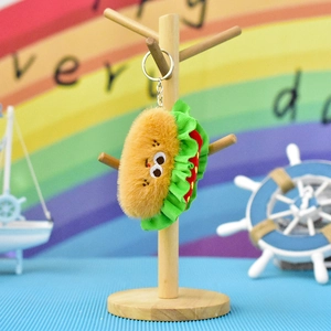 Close-up of a cute plush taco keychain hanging on a wooden display stand.
