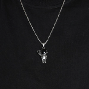Close-up of silver astronaut pendant with black visor holding a star on bead chain