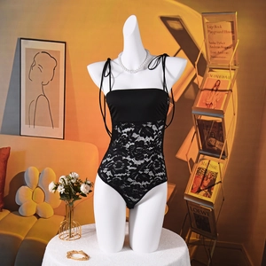 Detailed view of black lace patchwork bodysuit with adjustable thin straps on a mannequin