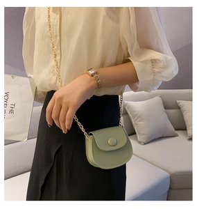 Vue détaillée du mini sac selle vert menthe avec chaîne dorée sur le mannequin
