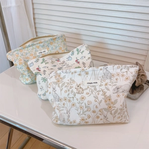 Detailed macro view of cream velvet floral makeup bags with simple wish fabric labels