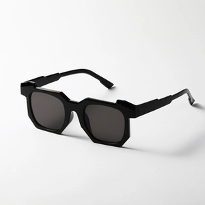 Detail view of foldable black sunglasses with thick frames at a 45-degree angle