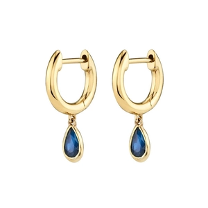Detailed macro view of gold hoop earrings with sparkling blue teardrop zircons on white backdrop