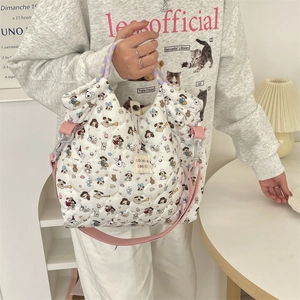 Détail du sac fourre-tout blanc matelassé avec motifs chiots de dessin animé et bandoulière