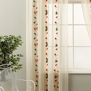 Detail of Christmas bell embroidery on semi-sheer beige lace fabric with berry patterns