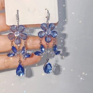 Close-up of blue crystal butterfly earrings with teardrop tassels and silver hooks