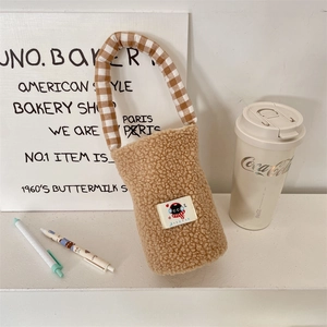 Detail of khaki sherpa water bottle carrier with plaid handle and cute cartoon patch