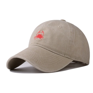 Close-up of vintage washed khaki cotton baseball cap featuring red crab embroidery detail