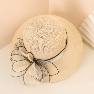 Detail of wide brim straw hat with large chiffon floral bow and woven texture