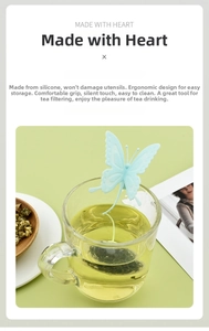Detail view of light blue butterfly silicone tea infuser hanging on glass cup edge