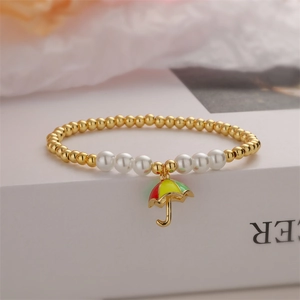 Dettaglio di bracciale con sfere metalliche dorate, perle e ciondolo a ombrello colorato