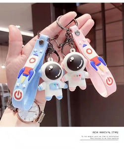 Vue détaillée de porte-clés astronaute en silicone bleu et rose avec dragonnes assorties